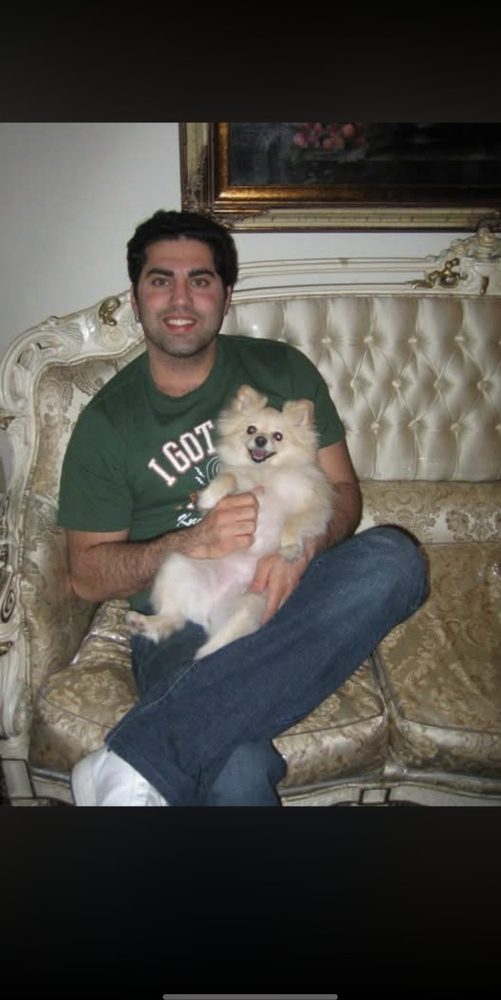 Yeron at home holding a small dog